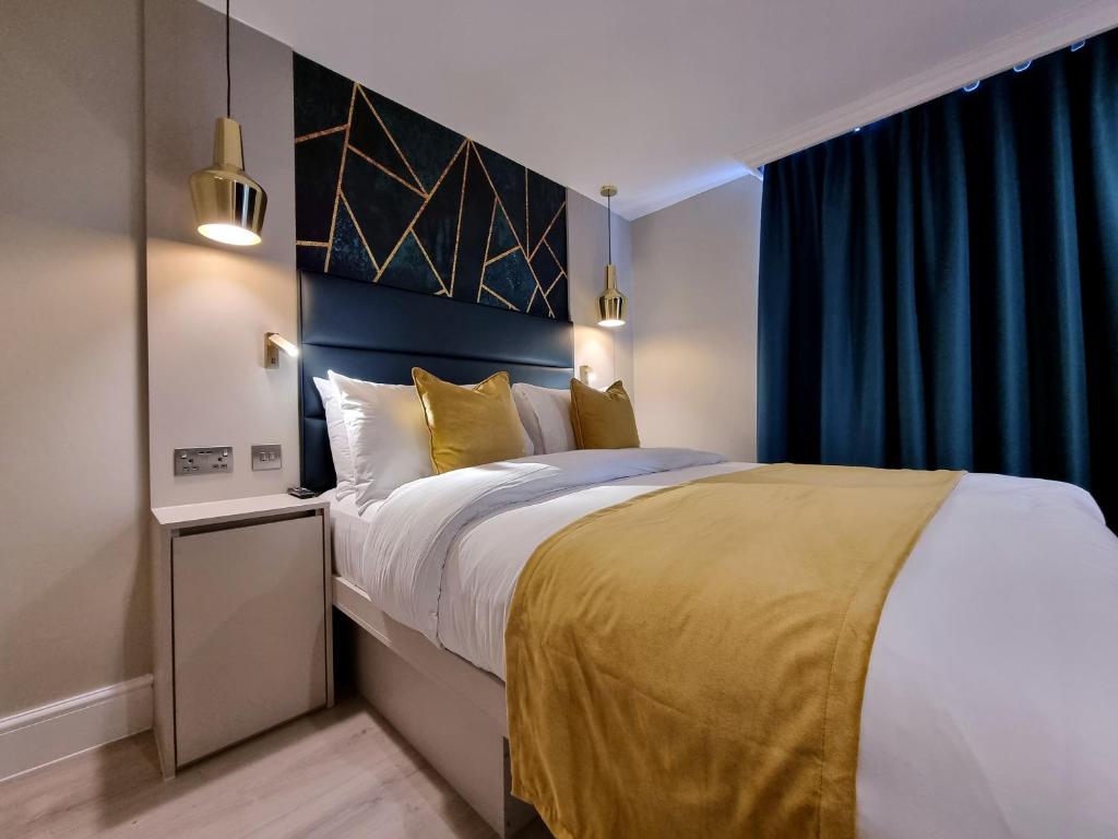 a bedroom with a large bed with yellow pillows at West Brompton Studios in London