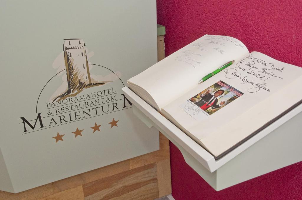 a book sitting on top of a table next to a desk at Panoramahotel &amp; Restaurant am Marienturm in Rudolstadt