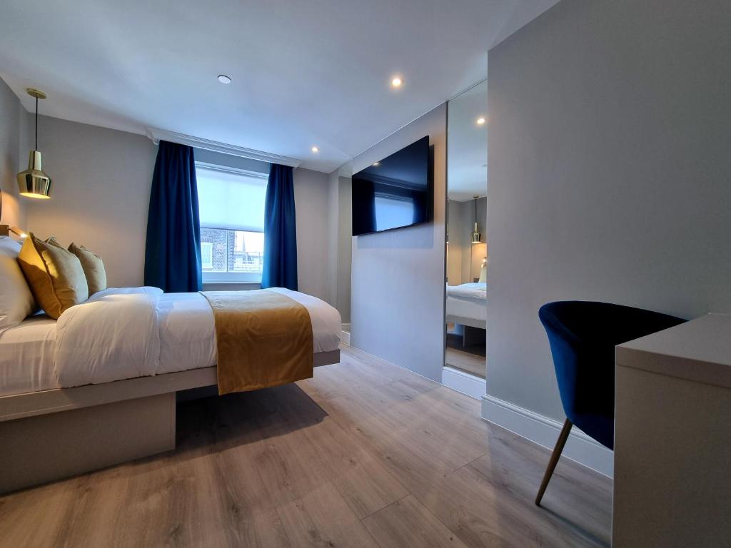 a bedroom with a bed and a desk and a window at West Brompton Studios in London