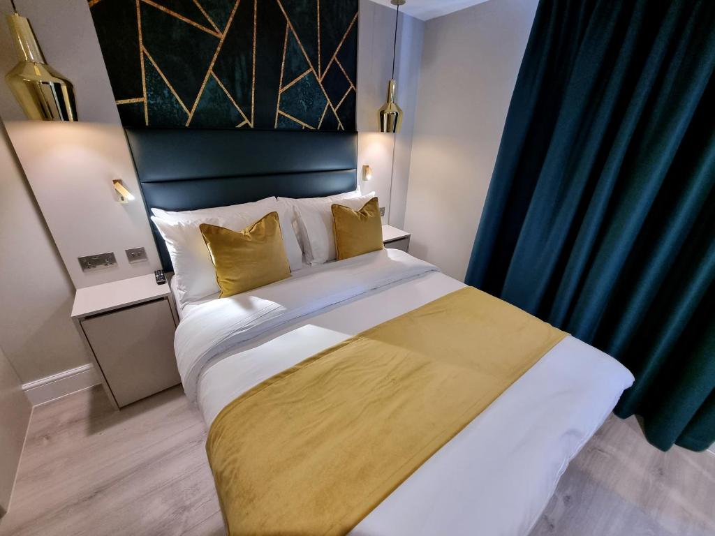 a bedroom with a large bed with yellow pillows at West Brompton Studios in London