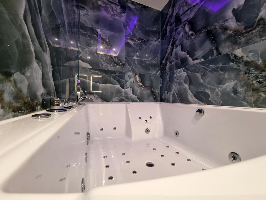 a bath tub in a bathroom with a stone wall at West Brompton Studios in London