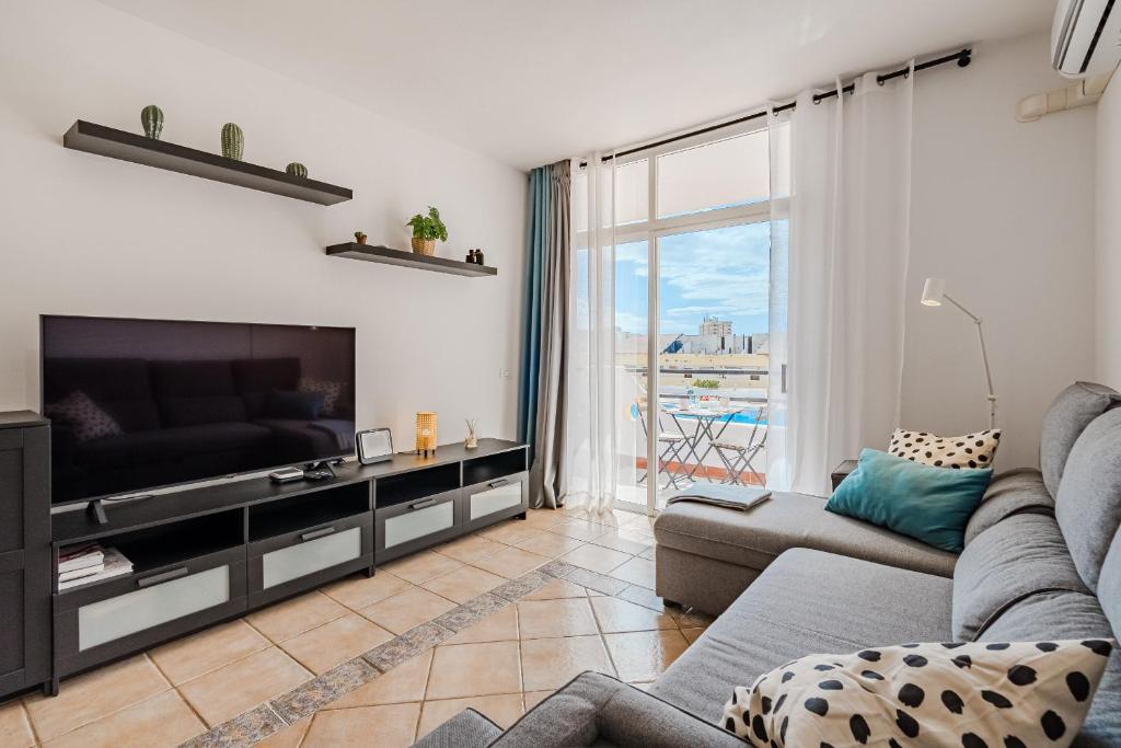 a living room with a couch and a television at Marina Palace with Swimming Pool in Adeje