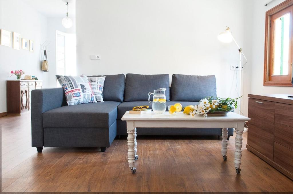 a living room with a blue couch and a coffee table at Mallorca beach home in Porto Cristo