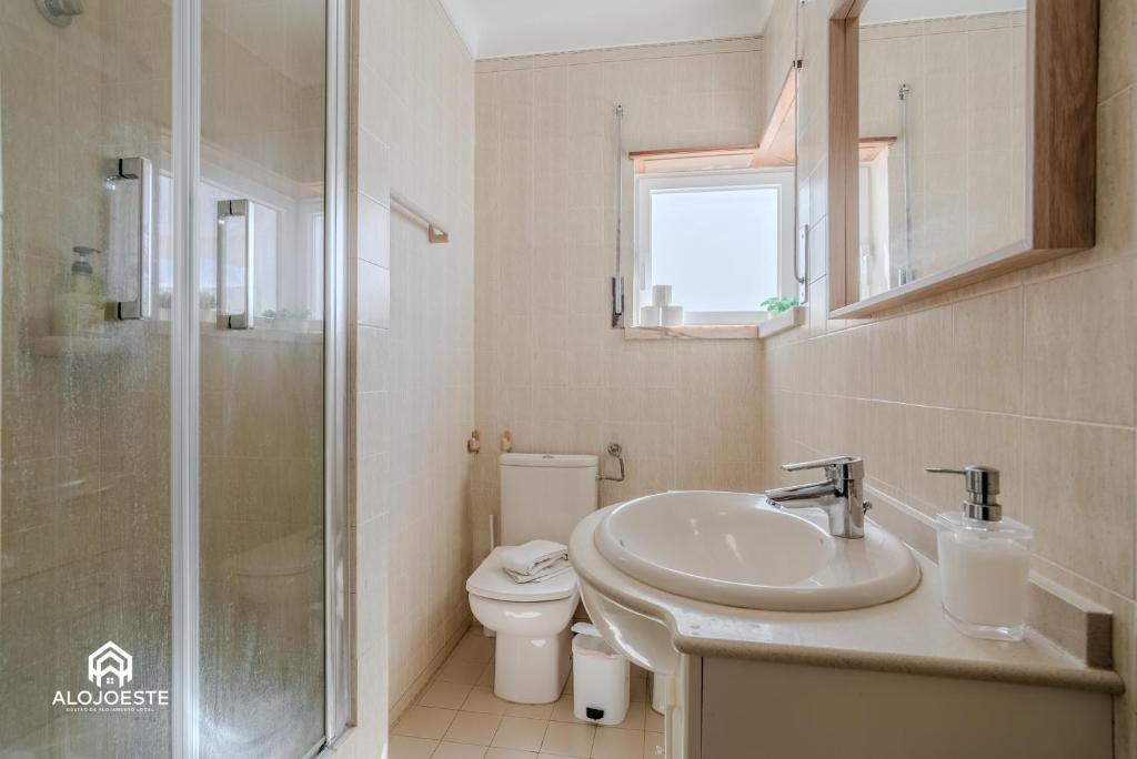 a bathroom with a sink and a toilet and a shower at Ericeira Panoramic Sea View Apartments in Ericeira