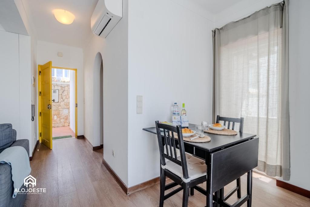a dining room with a black table and chairs at Ericeira Panoramic Sea View Apartments in Ericeira