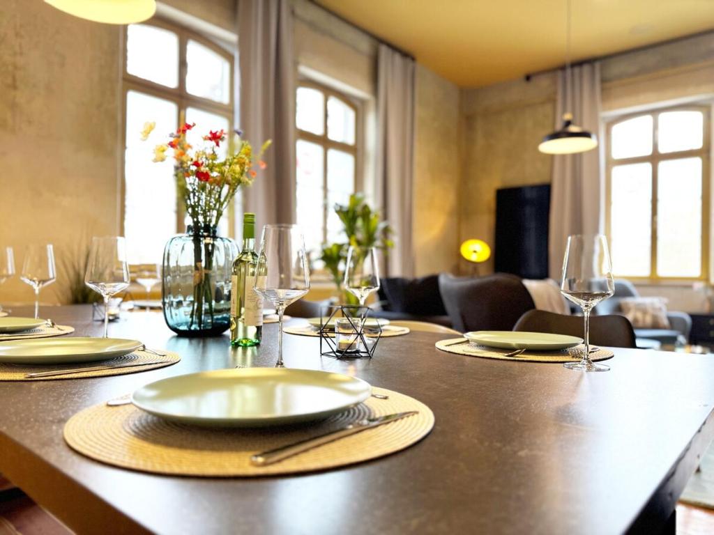 a table with plates and wine glasses on it at Platanenblick in Schönebeck an der Elbe in Schönebeck