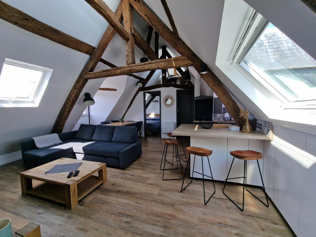 un salon avec un canapé bleu et une table dans l'établissement Le Henri IV - Vue Cathédrale, Parking, à Rouen