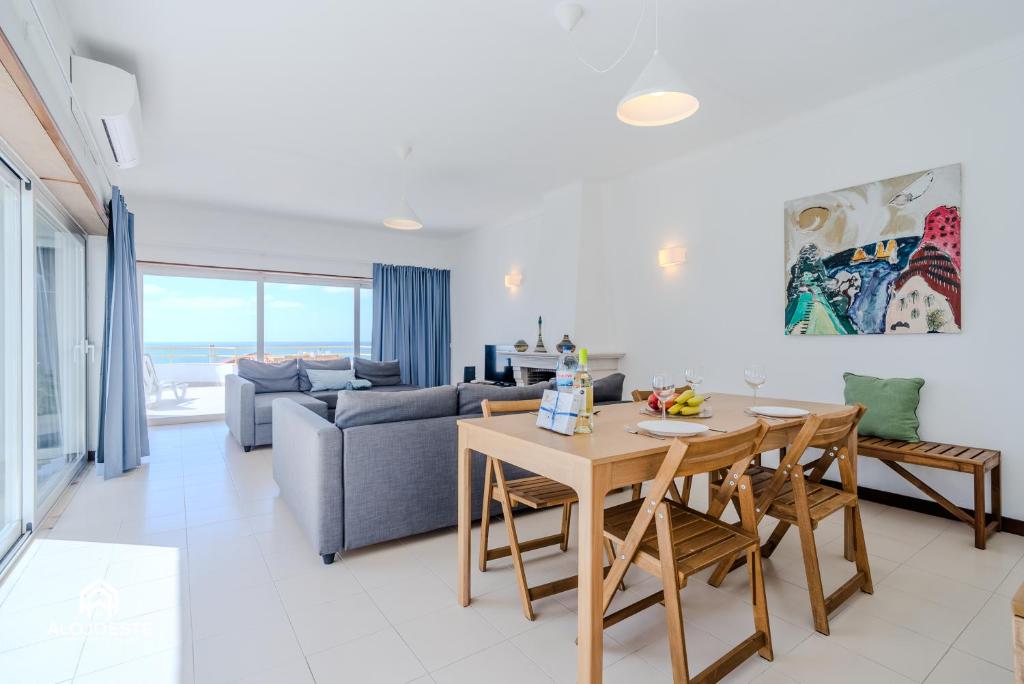 a living room with a table and a couch at Ericeira Panoramic Sea View Apartments in Ericeira
