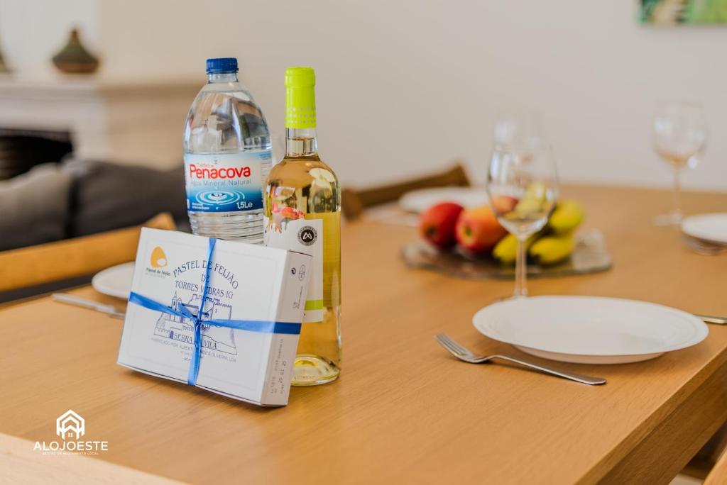 a table with a bottle of wine and a sign on it at Ericeira Panoramic Sea View Apartments in Ericeira