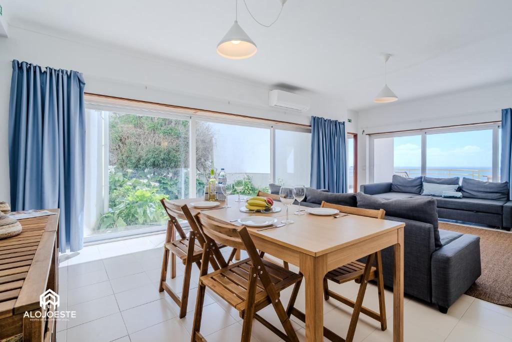 a kitchen and living room with a table and chairs at Ericeira Panoramic Sea View Apartments in Ericeira
