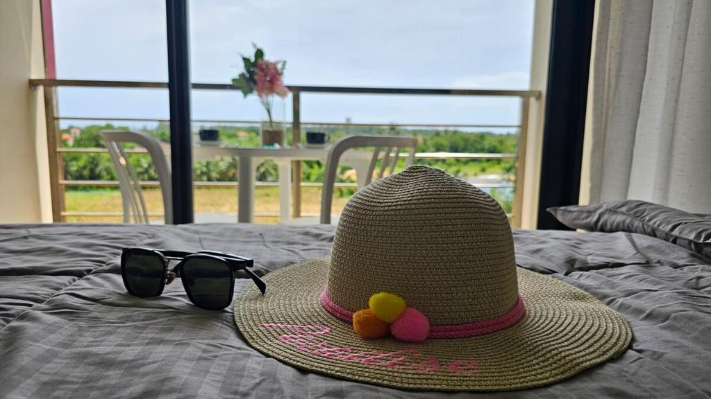 een hoed en een zonnebril en een hoed en een bril bij Sunset view studio at 777 Beach Condo in Ban Mai Salae