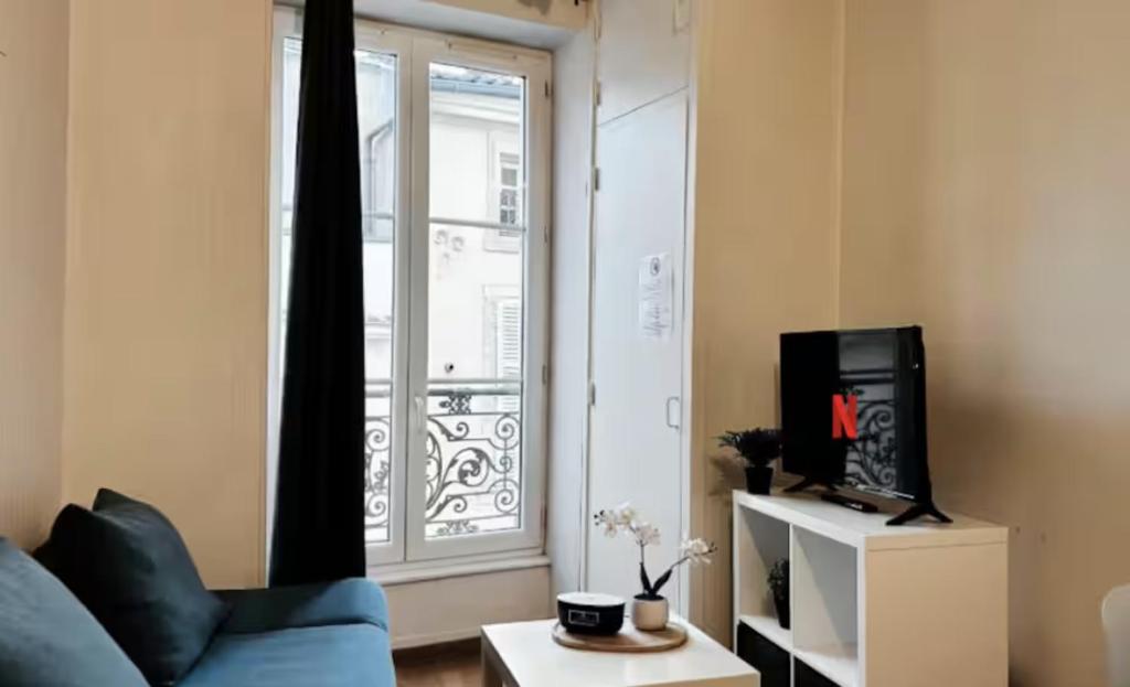 a living room with a blue couch and a window at Le Saphir Central - Cosy - Gare in Mâcon