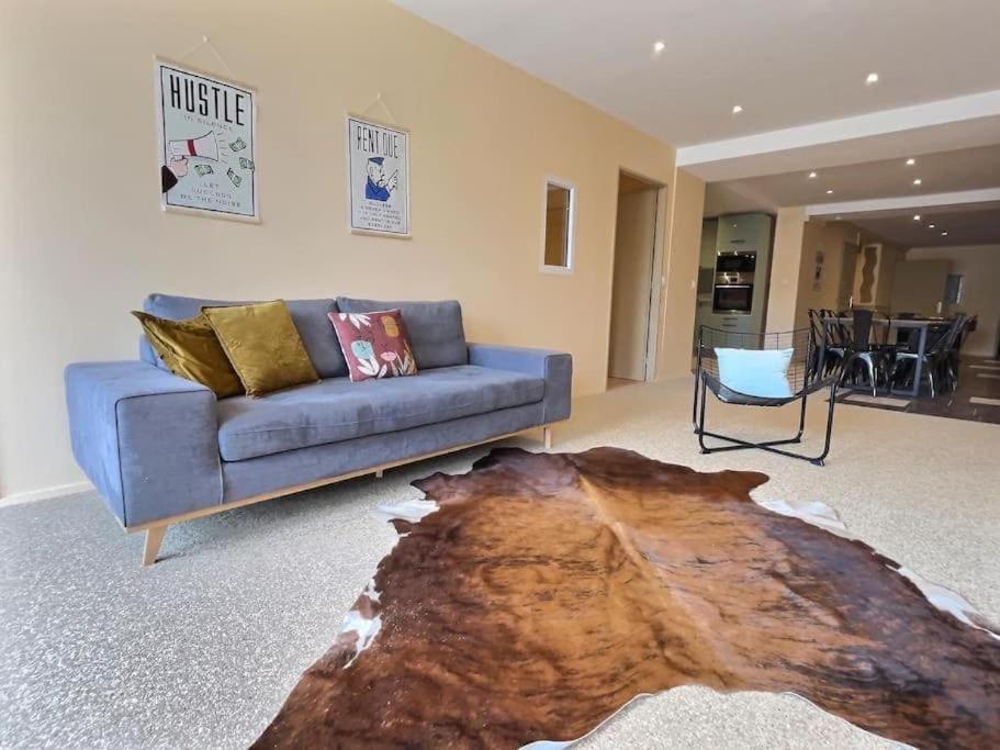 a living room with a blue couch and a wooden table at Monopoly - Parking in Bourg-de-Péage