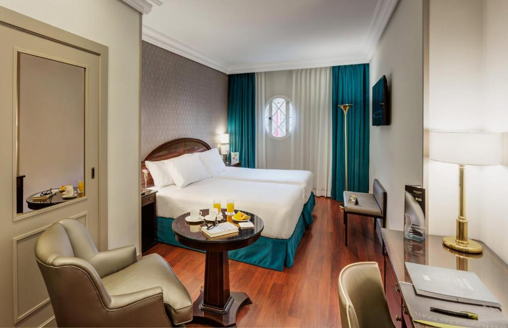 A bed or beds in a room at Sercotel Gran Hotel Conde Duque