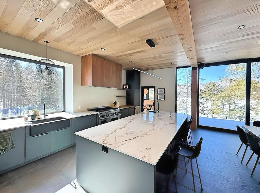 a kitchen with a large island in the middle at Scandinavian Luxury Chalet, Hot Tub, Private Dock, Sleeps 14!! Min 32 nights in Sainte-Lucie-de-Doncaster