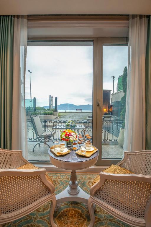 a room with a table and chairs and a large window at MFB Tarabya Hotel in Istanbul