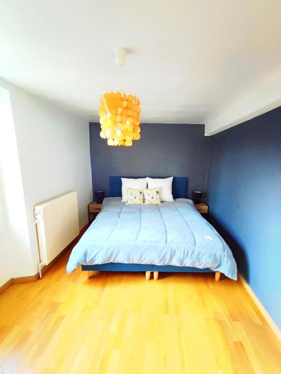 une chambre avec un grand lit avec un mur bleu dans l'établissement maison chaleureuse avec jardin, à Savigny-sur-Orge