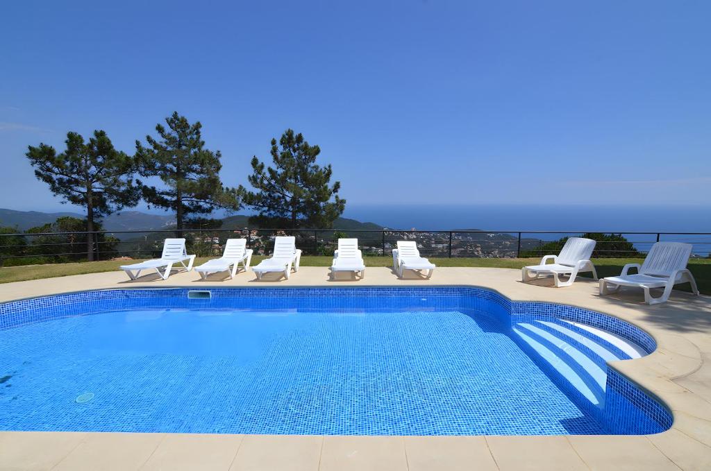 a swimming pool with chaise lounge chairs and a swimming pool at Villa Roselles in Lloret de Mar
