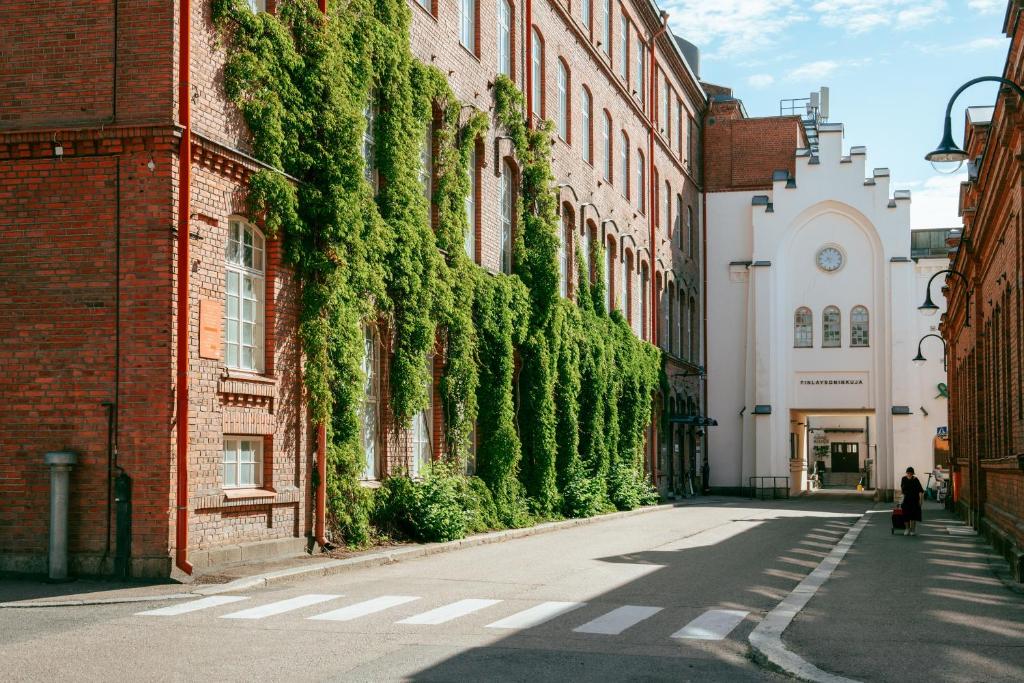 a building with ivy growing on the side of it at Uumen Hotels - Tampere, Finlayson in Tampere