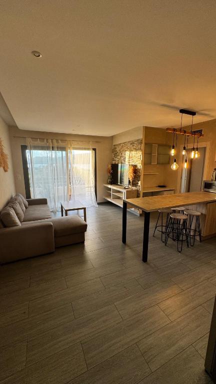 a large living room with a couch and a table at Appartemment vue mer 50m2 in Propriano
