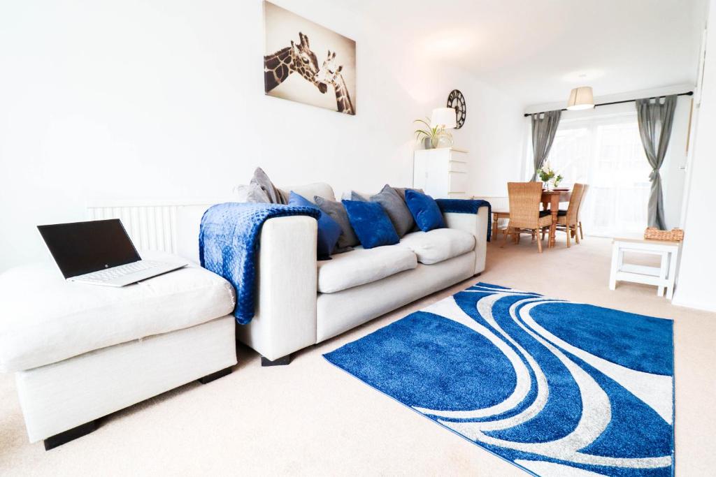 a living room with a white couch and a blue rug at Polperro House - Chic & Stylish Home in Orpington
