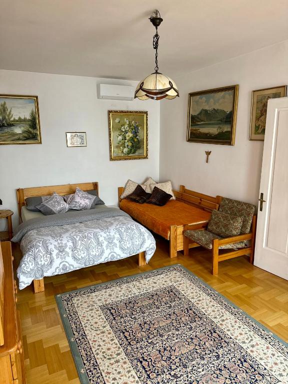 a bedroom with two beds and a table and a couch at Perfect Remote-Workplace in Sunny Apartment in Myślenice