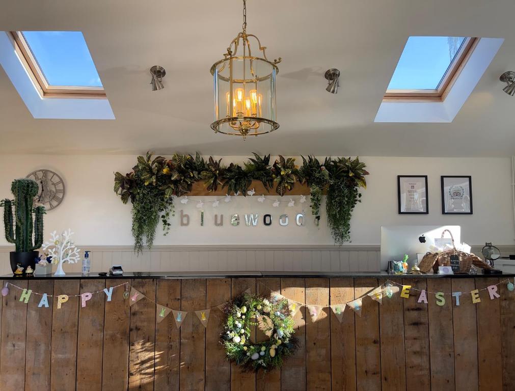 a restaurant with a bar with flowers and a chandelier at Norton Plus Lodge 29 in Kingham