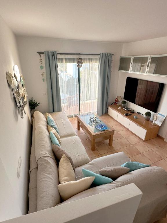 a living room with a couch and a table at Can Blau Formentera Apartamento in Es Pujols