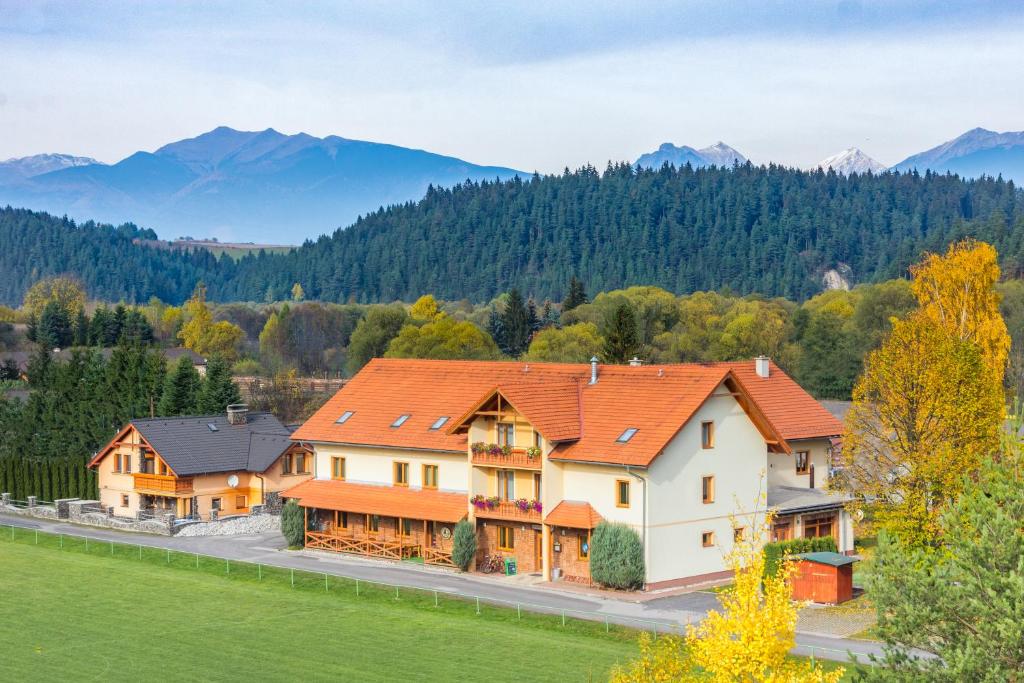 a home in the mountains with mountains in the background at Penzion Larion in Kráľová Lehota