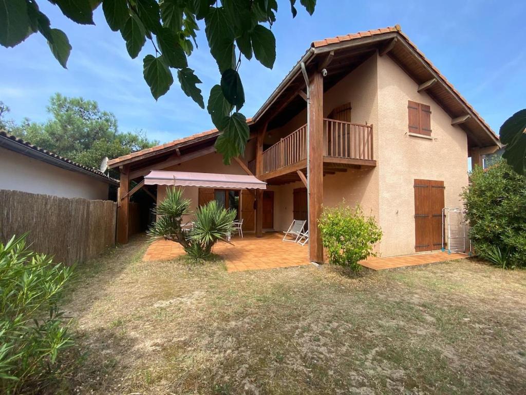 une maison avec une grande cour devant elle dans l'établissement Au pied de la dune, agréable maison T5 et jardin, à Moliets-et-Maa