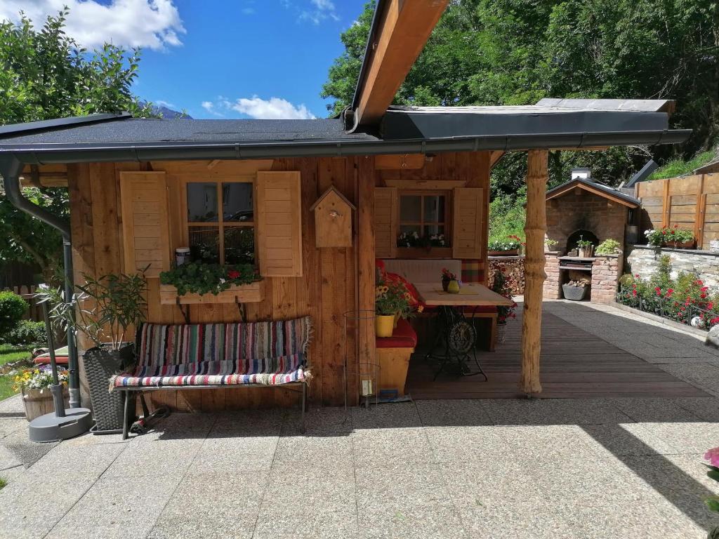 Un cobertizo con un banco en un patio. en Hänsler's Hof, en Arzl im Pitztal