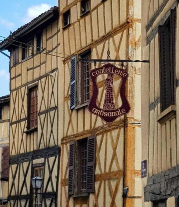 un bâtiment avec une enseigne sur le côté dans l'établissement Nouveau Maison Typique, à Thiers