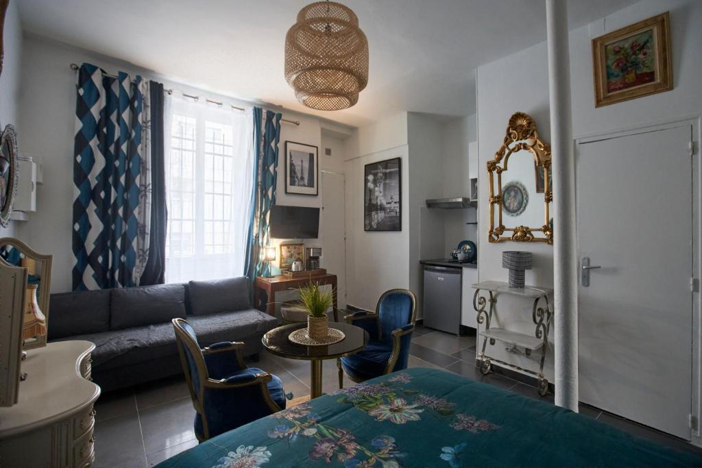 ein Wohnzimmer mit Couch und Tisch in der Unterkunft Paris est merveilleux - Buttes-Chaumont in Paris