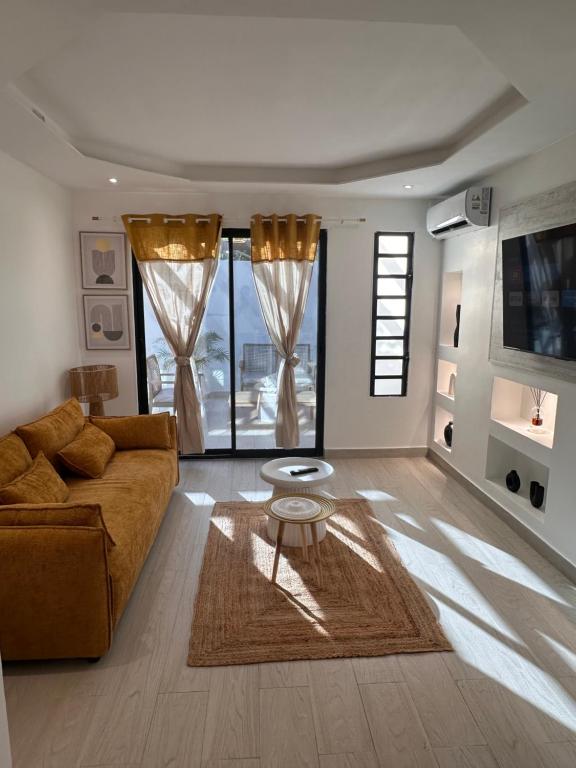 un soggiorno con un divano e un tavolo di CYRUS Hôtel -Housse cœur de ville a Pointe-à-Pitre