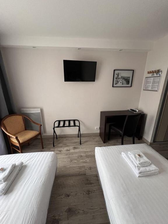 TV a/nebo společenská místnost v ubytování Au Bec Fin Hôtel