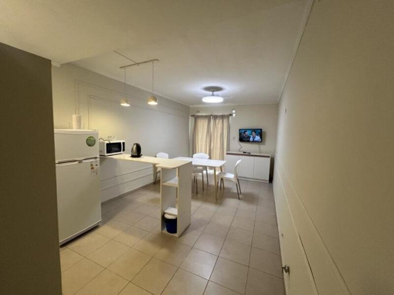 cocina con nevera blanca y mesa con sillas en HOUSE AND SUITE SF RIVADAVIA, en Santa Fe