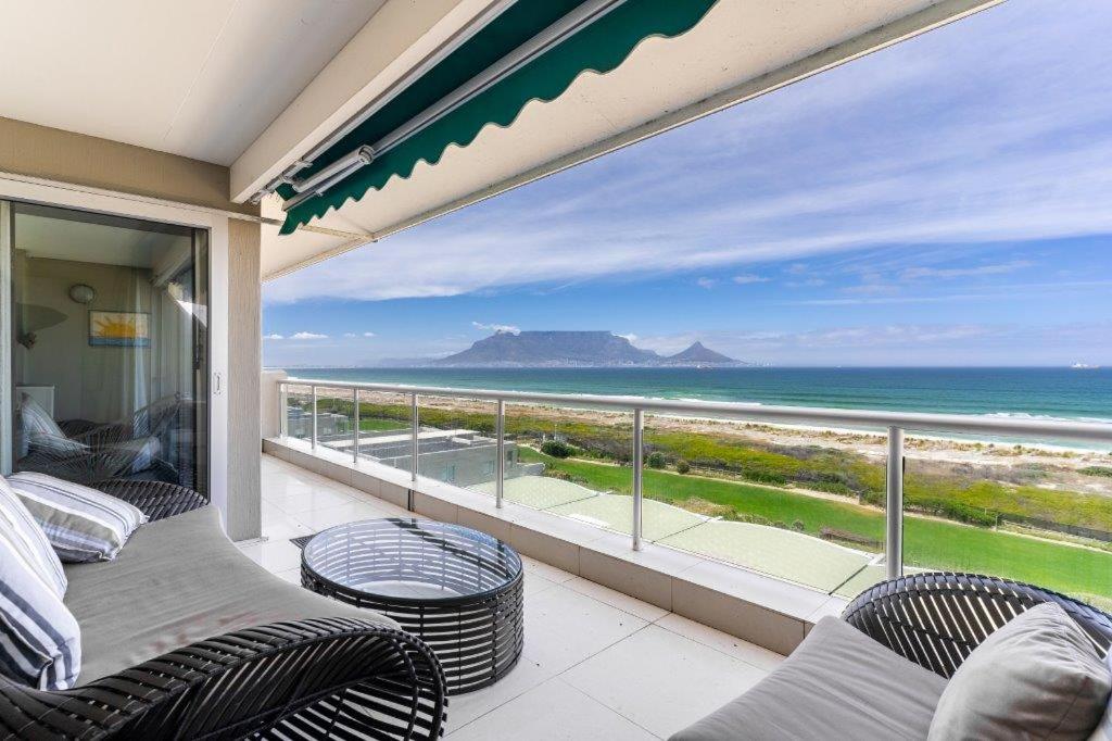 a balcony with chairs and a view of the ocean at Dolphin Beach Penthouse in Cape Town