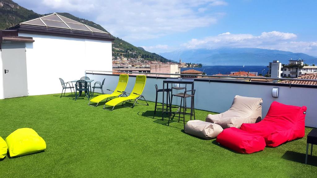 balcón con mesa y sillas amarillas y rojas en Lake Garda Hostel en Salò