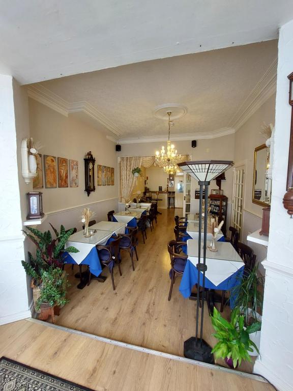 Un restaurante con mesas y sillas y una lámpara de araña. en Westfield House, en Blackpool