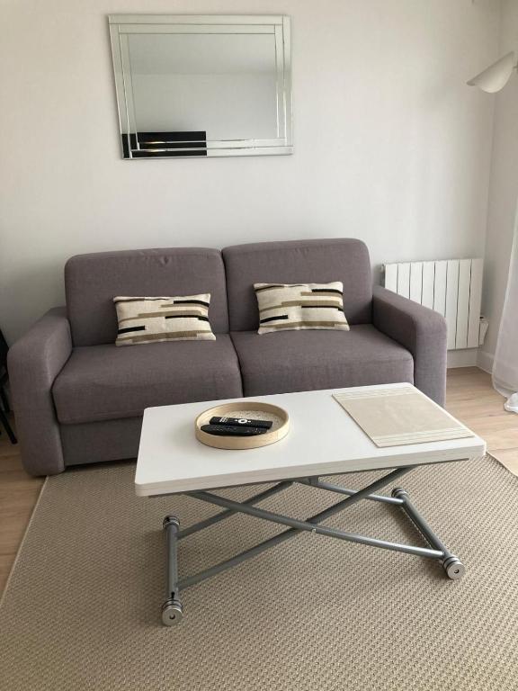 un salon avec un canapé et une table basse dans l'établissement Grand studio hyper centre avec balcon TOUT REFAIT MARS 2025, à Deauville
