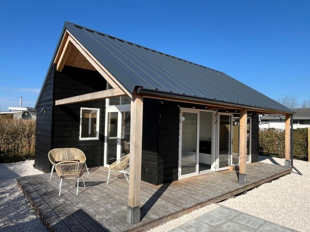 アウウドルプにあるFijn strandhuis dicht aan zee!の黒屋根の黒いキャビン