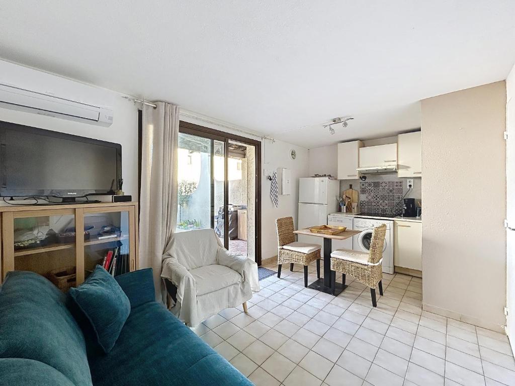 salon z niebieską kanapą i kuchnią w obiekcie Maison confort 6 pers avec climatisation - FR-1-475-222 w Saintes-Maries-de-la-Mer