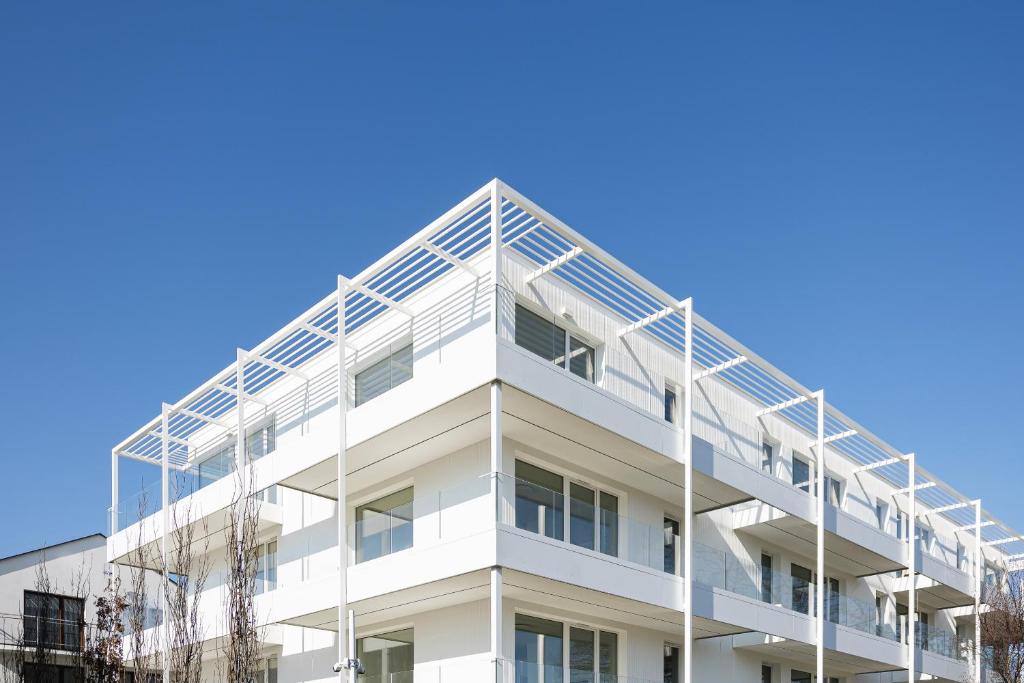 a white building with a ladder on the side of it at PROMENADA apartamenty & spa PRZY PLAŻY in Władysławowo