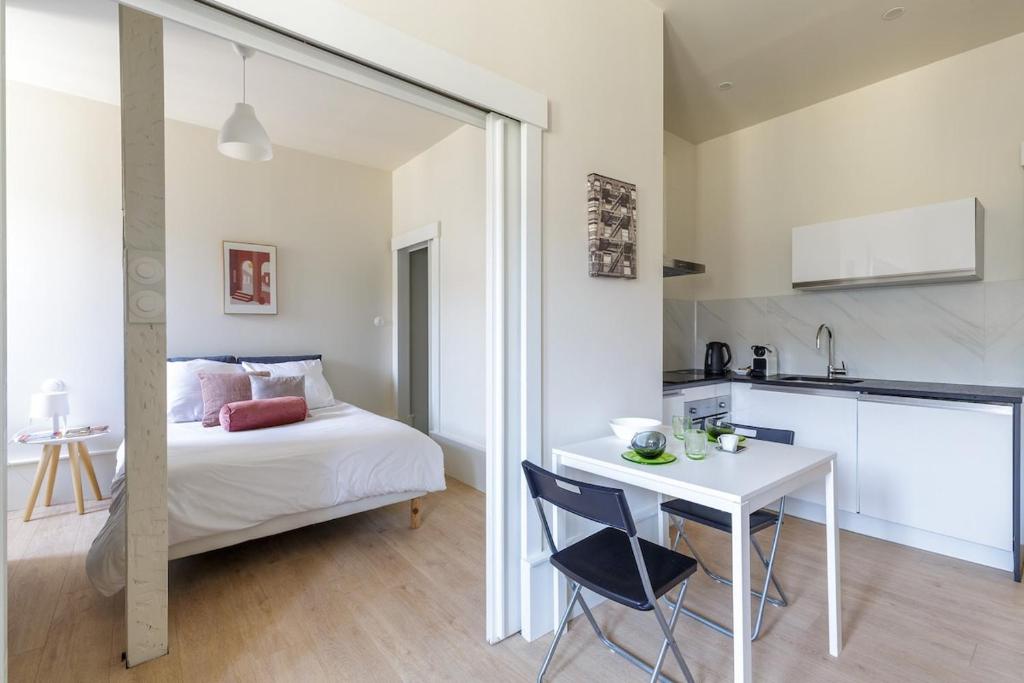 une chambre avec un lit et une table et une cuisine dans l'établissement Neustadt central et paisible, à Strasbourg