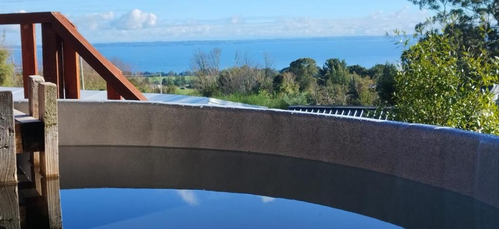 una pared de hormigón con vistas al agua en Adilauquén Cabañas y Tinajas Calientes, en Puerto Varas