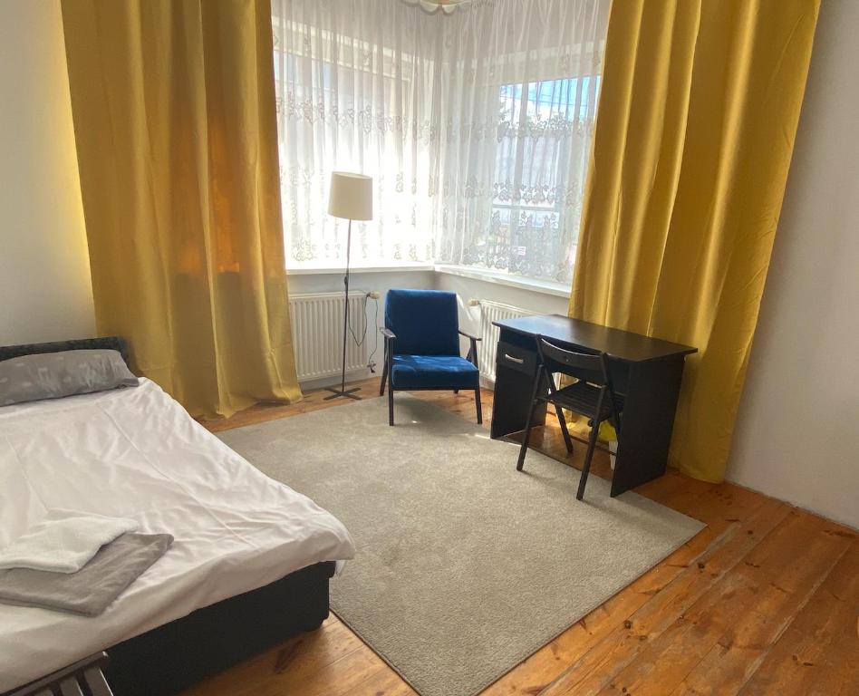 a bedroom with a bed and a desk and a window at Dom wakacyjny Blisko Plaży in Gdynia