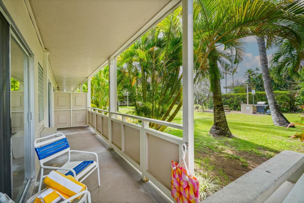 a porch with a couple of chairs and palm trees at "Island Time" at Plantation Hale D4 in Kapaa