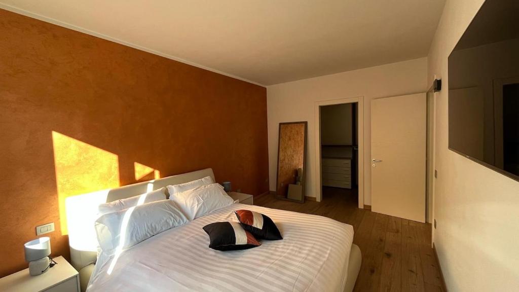 a bedroom with a large white bed with a hat on it at Caramaschi Verona Apartment in Negrar