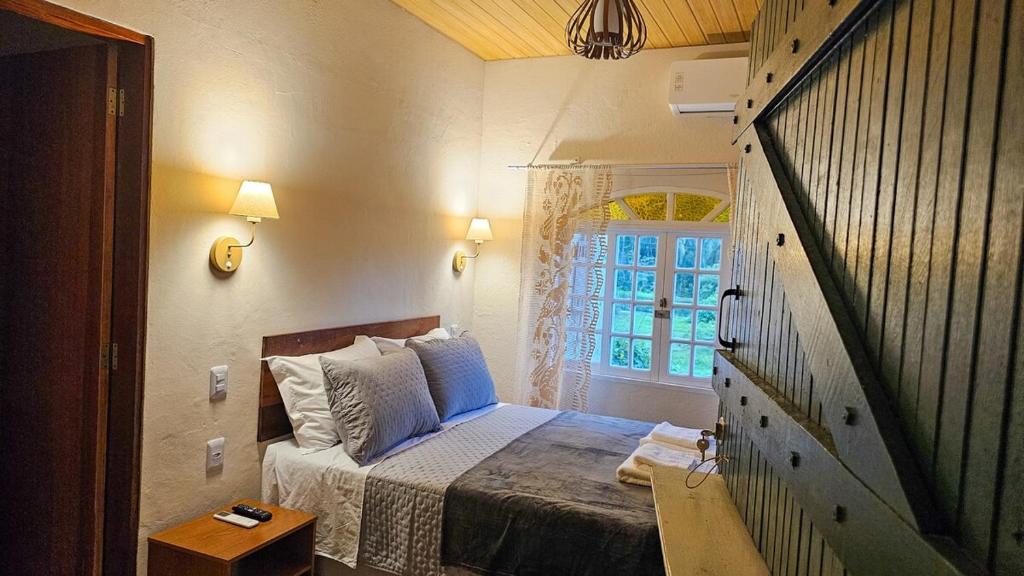 a small bedroom with a bed and a window at Recanto da Susanne in Resende
