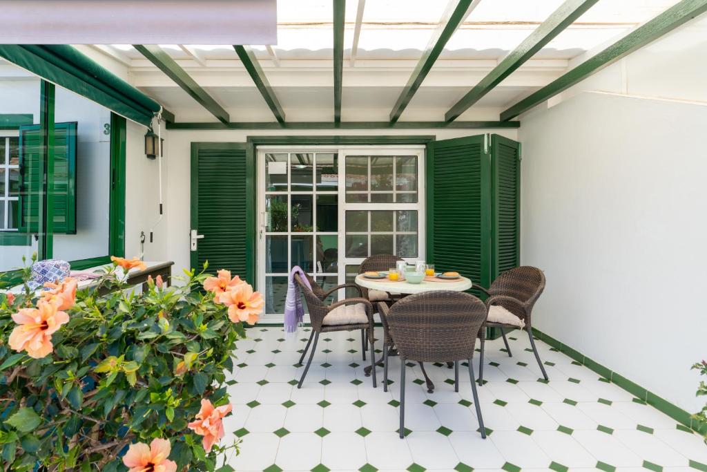eine Terrasse mit Tisch und Stühlen und Blumen in der Unterkunft Bungalow Angelika Campo Golf in San Bartolomé de Tirajana